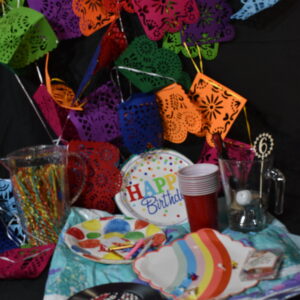 Bunting, sea scape plastic table cloth, jug of straws, party plates, cocktail sticks, plastic cups, place mats, cake candles & holders